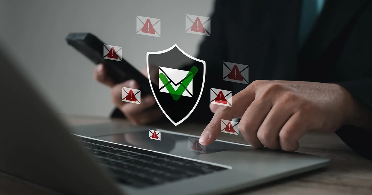 Person using a laptop and smartphone while warning icons surround a shield with a green check.